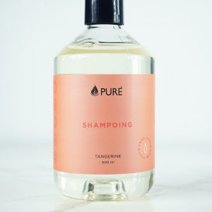 Pure brand organic and biodegradable shampoo in a clear bottle with orange label.